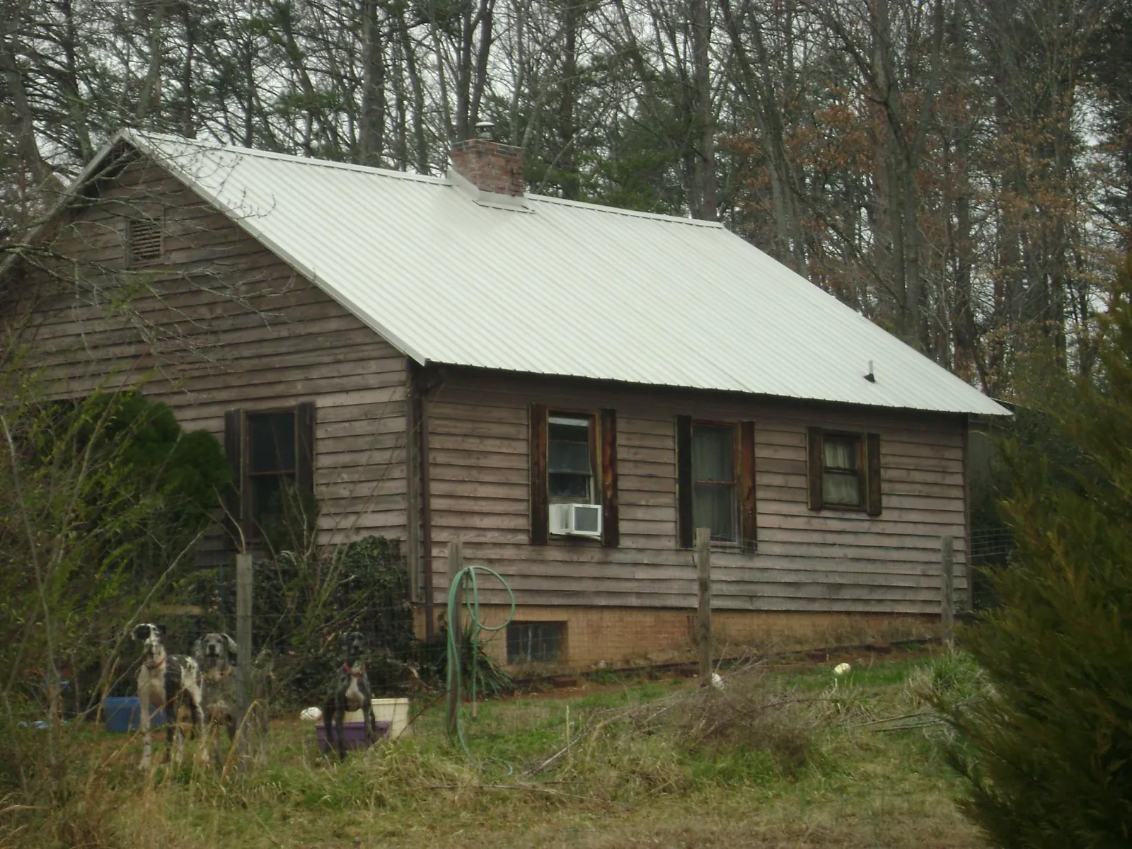 White metal roof on an old wood sided farmhouse, from a Metal Roof Installation job in Crosby